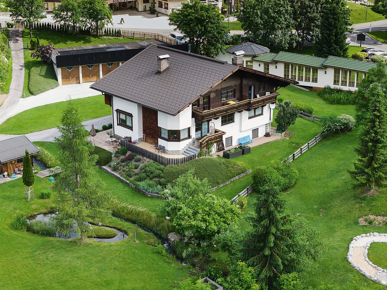 Ferienhaus Falger aus der Ferne und von oben umgeben von grüner Wiese und Garten